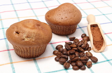 Fresh baked muffins, coffee grains and powdery cinnamon