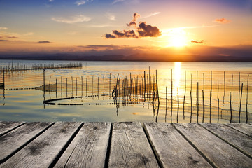 Fototapeta na wymiar el sol naciente en el lago de la pesca