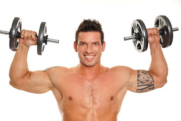 Handsome man exercises with dumbbells over head