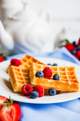 Belgian waffles with berries on rustic background