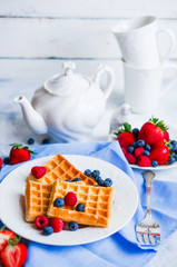 Belgian waffles with berries on rustic background