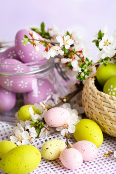 Composition with Easter eggs in glass jar and wicker basket,