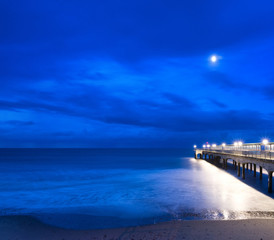Twilight schemering landschap van pier die zich uitstrekt in zee met moo