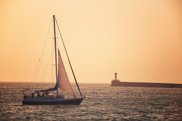 Fototapeta premium Sail boat against sea sunset