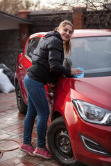 Fototapeta na wymiar young woman washing red car