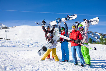 Five snowboarders holding oards and skies together - obrazy, fototapety, plakaty