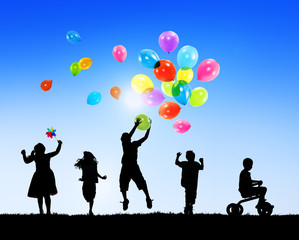 Silhouettes of Children Playing With Balloons