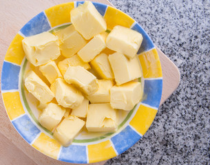 A group of melting butter in a bowl over granite surface