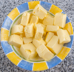 A group of melting butter in a bowl over granite surface