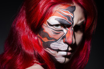 Woman with face painting in dark room