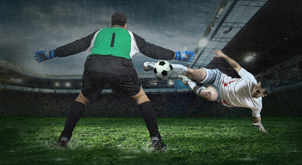 Obraz na płótnie Canvas Two football players in action under rain in stadium