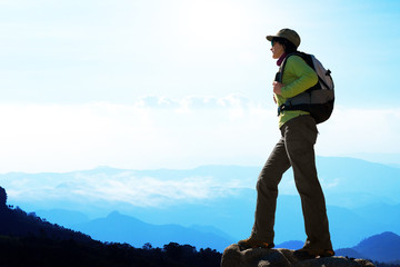 Female hiker against blue mountain background.