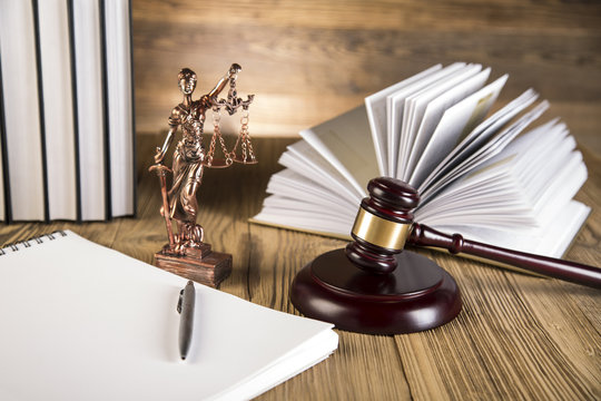Lady of justice, wooden & gold gavel and books on wooden table