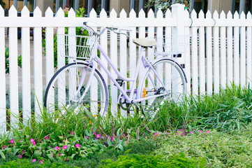 women's bicycl lean at white  fence