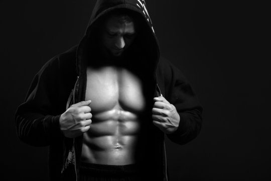 black and white strong man in the hood showing his abs