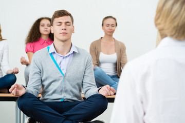 group of young people meditating