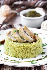 Couscous with pesto sauce, fried sliced pork, tasty dish