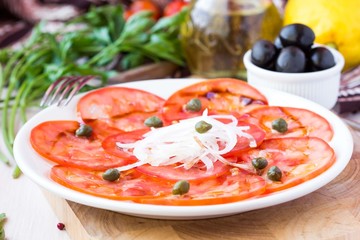 Fresh healthy tomato carpaccio with capers, balsamic vinegar, ol