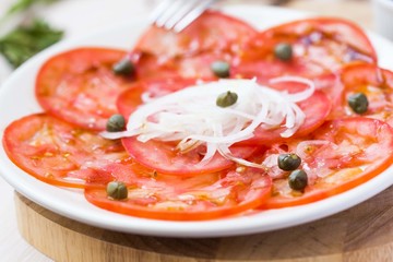 Fresh healthy tomato carpaccio with capers, balsamic vinegar