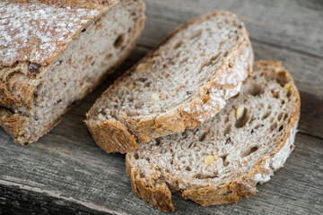 Sliced brown bread on wooden table.