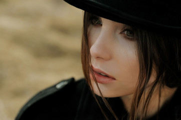 portrait of beautiful girl in hat looking field