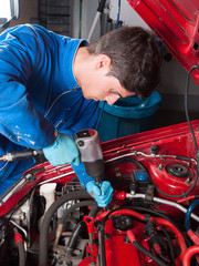 mechanic repairing a car engine - obrazy, fototapety, plakaty