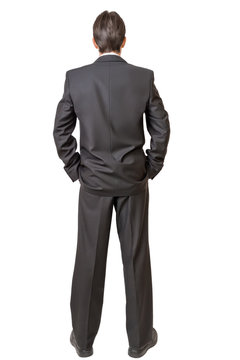 Backside of man in black suit keeping hands in pockets