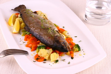 Fried whole trout, vegetables, lemon, water