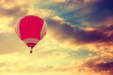 Hot Air Balloon Flying over Dramatic Sunset Sky