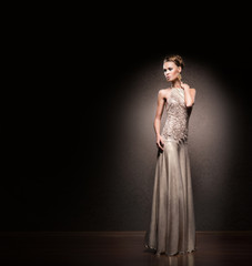 Fototapeta premium Beautiful woman in a glamour dress in a studio