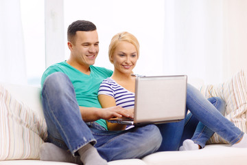 Fototapeta na wymiar smiling happy couple with laptop at home