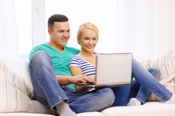 smiling happy couple with laptop at home