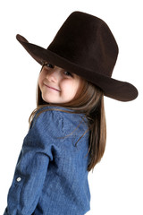 Cute young cowgirl looking over her shoulder smiling