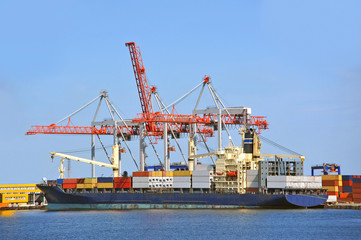 Container stack and ship under crane bridge