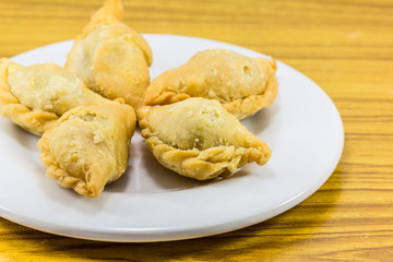 Five curry puffs on white plate