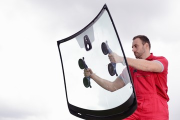 mechanic holding windshield