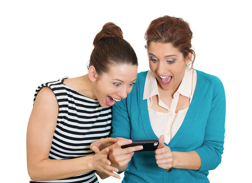 Surprised women looking on cell mobile phone white background 