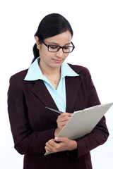 Young business woman writes information on clipboard
