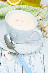 Delicate mushroom sauce in cup on wooden table close-up