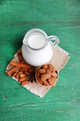 Almond milk in jug with almonds in bowl,