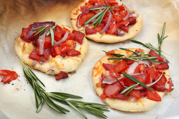 Small pizzas on baking paper close up