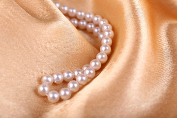 Beautiful pearls on golden silk cloth