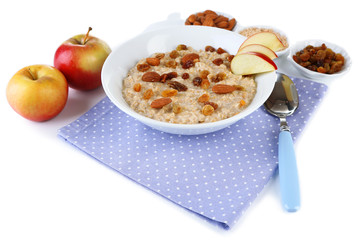 Tasty oatmeal with raisins and apples isolated on white