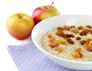 Tasty oatmeal with raisins and apples isolated on white