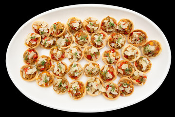 Vegetable appetizers on plate, isolated on black