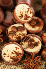 Tasty chocolate candies with coffee beans and nuts, close up