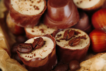 Tasty chocolate candies with coffee beans and nuts, close up