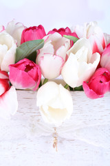 Fototapeta na wymiar Beautiful tulips in wooden box, on light background