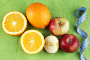 Fruits with measuring tape on wooden background