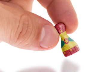 Hand holding wooden pawn, flag painting, selective focus